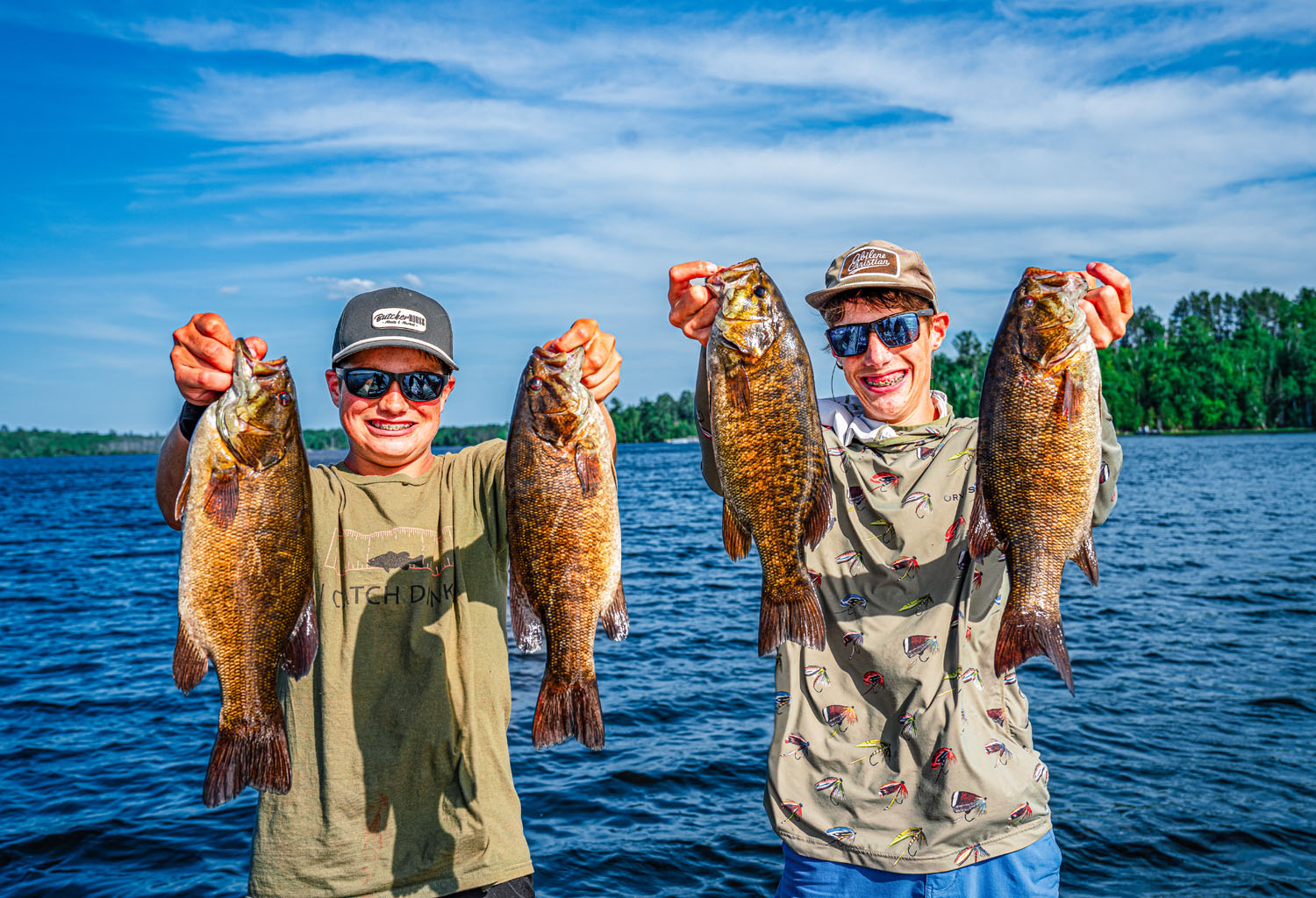 Two anglers holding up their Vermillion catch on the lake
